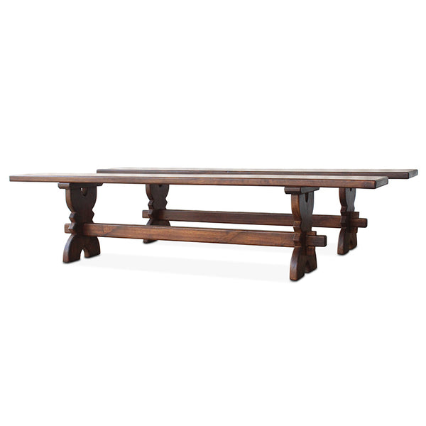 Vintage walnut bench with dark stained top and carved trestle base, side view