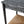 Black console table edge with woven paper rush shelf and visible distressed grain.
