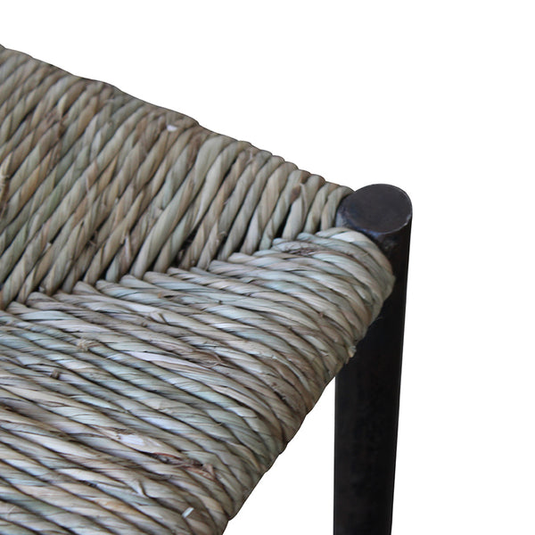 Woven rush stool seat corner with dark metal frame and round rivet cap